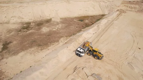 Wheel loader load sand in dump truck in open pit. Stock Footage 219866860