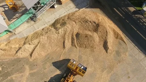 Wheel loader scooping up wood chips and transporting it Stock Footage 71272555
