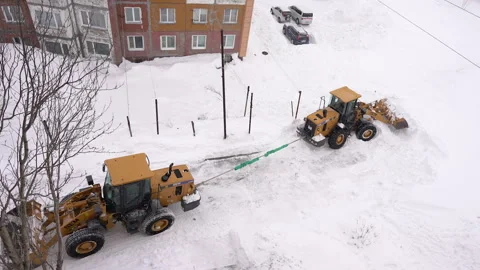 Wheel Loader tows and pulls out another Wheel Loader, which is deeply stuck in Stock Footage 327627659