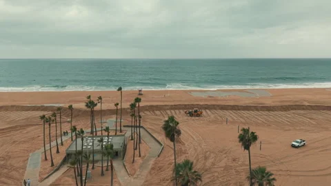Wheel loader working on sandy Newport Beach during coastal flood Vídeos de archivo 347744430