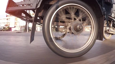 Wheel of a motor rickshaw spinning as it cruises down a city street Vidéo 60626472