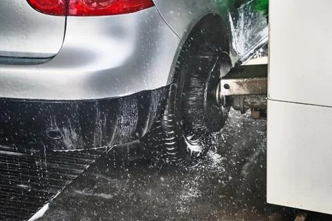 Wheel scrub brush in action at automatic car wash service Stock Photos
