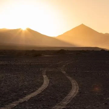 Wheel tracks in sand in dramatic landscape. Car tire tracks in sand. Dirt ... Stock Photos