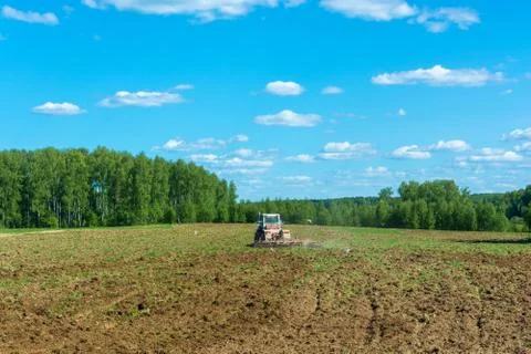 Wheel tractor working in the field. Stock Photos