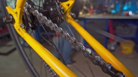 Wheel of the yellow bicycle is spinning. Workshop, bicycle repair Video stock 193482624