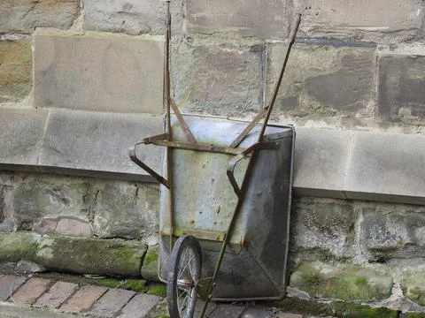 Wheelbarrow against a wall Stock Photos