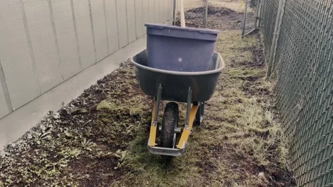Wheelbarrow carrying container in yard 스톡 동영상 332694511