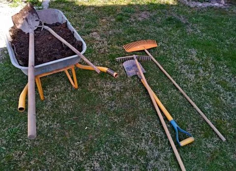 Wheelbarrow with compost and tools to prepare the garden for planting Stock Photos