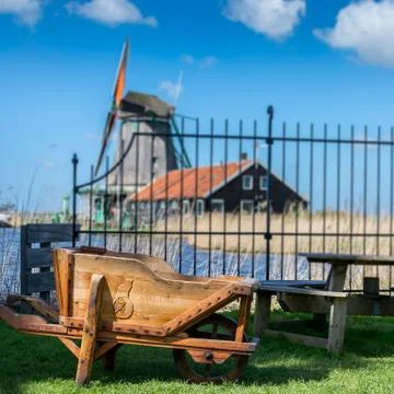A wheelbarrow with a windmill on the background Stock Photos