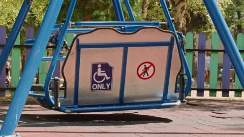 Wheelchair Accessible Swing at Empty Public Playground Stock Footage 346334129