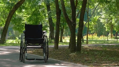 Wheelchair left empty in park Stock Footage 77360402