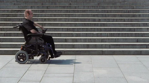 Wheelchair looking for a way up Stock Footage 32355571