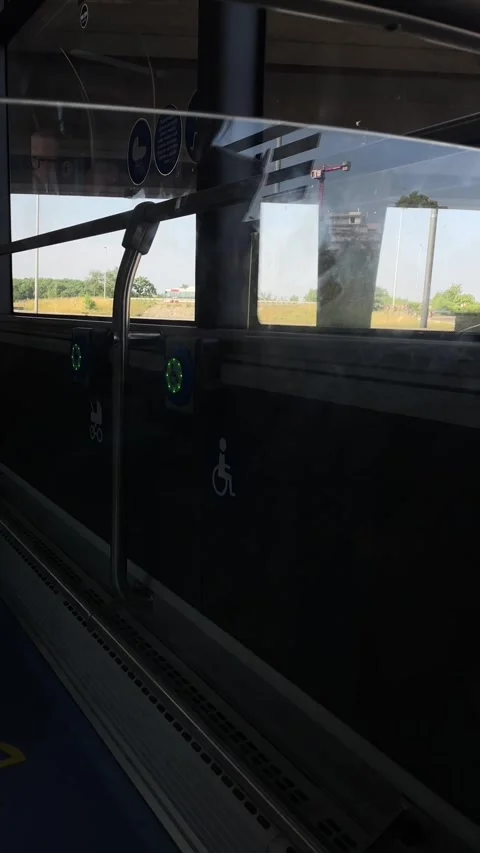 Wheelchair priority area inside bus seen through reflective side window with Stock Footage 344586821