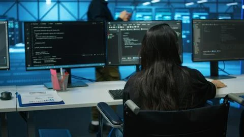 Wheelchair user in data center reading paperwork, reviewing rigs performance Stock Photos