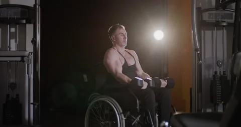 Wheelchair user doing dumbbell exercises in the gym. Video stock 146792033