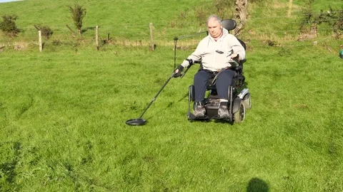 Wheelchair user wiith a metal detector in a field 3 Stock Footage 145894271