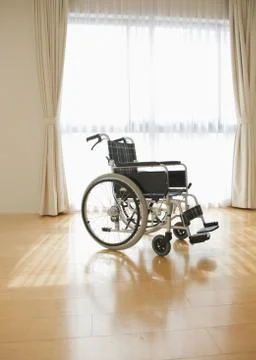 Wheelchair by a window Stock Photos