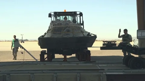 Wheeled loader lowering pallet of cargo onto frame Stock Footage 85840425