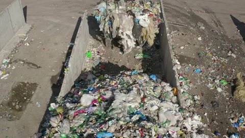 Wheeled loader operating on landfill site, carrying and dumping waste, aerial Video stock 234213389