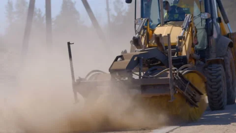 A wheeled tractor sweeps debris and dirt from the road with a rotating brush Stock Footage 147632927