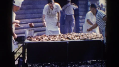 WHEELING OHIO-1957: Multiple Men Cooking And Turning Meat On An Open Barbecue Stock Footage 127279341