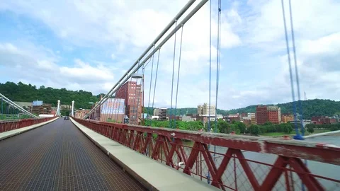 WHEELING WEST VA, DRIVING SHOT, ACROSS OLD SUSPENSION BRIDGE INTO TOWN Stock Footage 110928782