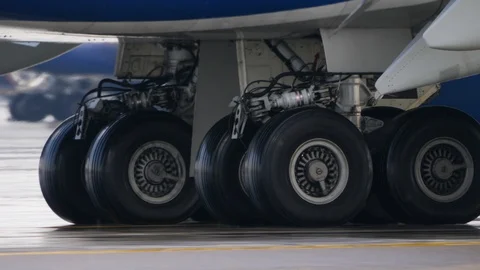Wheels of aircraft undercarriage. Close up of taxiing airplane landing gear Stock Footage 94514193