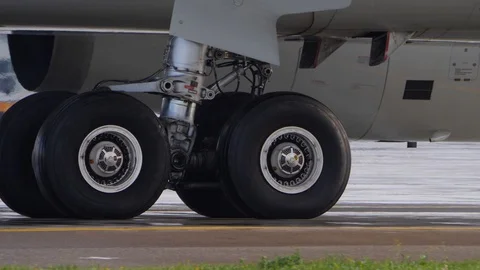 Wheels of aircraft undercarriage. Close up of taxiing airplane landing gear Stock Footage 94514285
