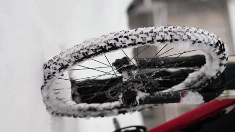 The wheels of a bicycle that rides through deep, freshly fallen snow Vidéo 263577972