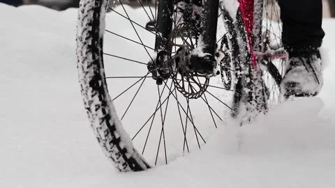 The wheels of a bicycle riding through deep, freshly fallen snow Stockbeeldmateriaal 263577808