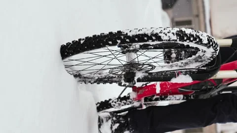 The wheels of a bicycle riding through deep, freshly fallen snow Stock Footage 263579076