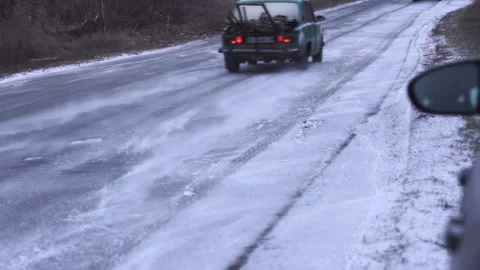 The wheels of a moving car raise clouds of light snow powder on the asphalt Stock Footage 305510297