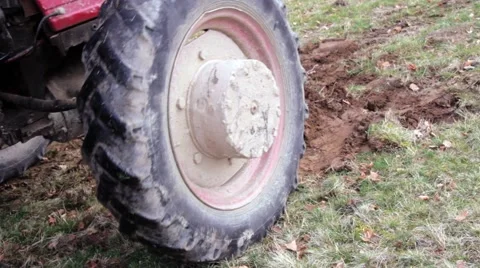 Wheels of a tractor going on pasture with green grass Stock Footage 62880832