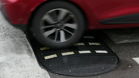 Wheels of the vehicles going over road hump on the street Stock Footage 167670998