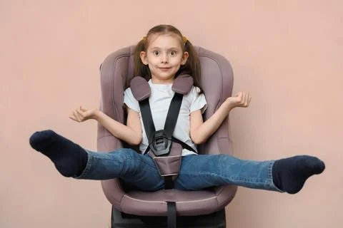 When is it time to change your child car seat. Funny little girl grew out of her Stock Photos