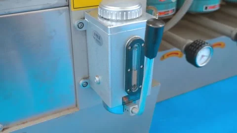 When lever of oiler is pressed, oil flows in volume that is visible on a meter Stock Footage 333363441