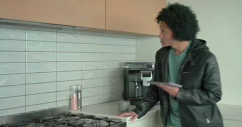 When opening guide, man tapping tablet inspecting coffee maker and stovetop in Stock Footage 340980383
