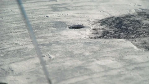 When playing golf, the orange ball falls into the snow hole Stock Footage 75316296