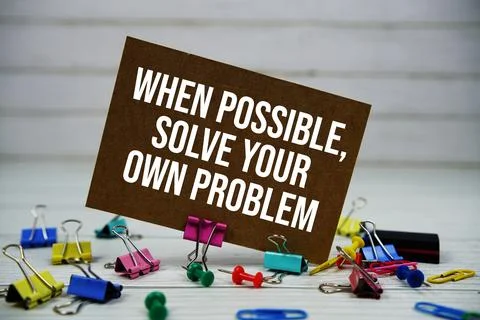 When Possible, Solve Your Own Problem text on paper card with stationary on.. Stock Photos