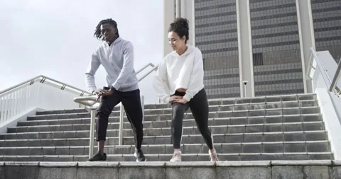 When stepping onto stairs Diverse friends warming with lunges, stretches and Stock Footage 340881237