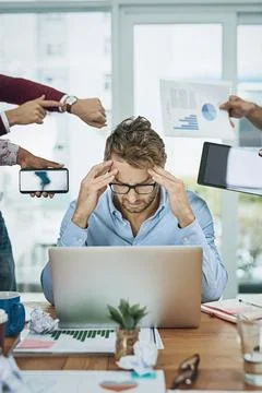 When there are more tasks than hours in a day. a young businessman looking Foto stock