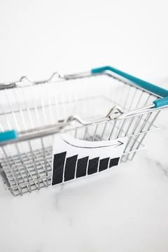 When will inflation go down. shopping basket with graph showing prices drop.. Stock Photos