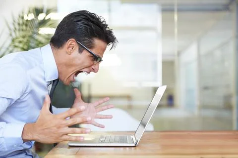 When your computer crashes. Profile of an angry businessman shouting at his Stock Photos