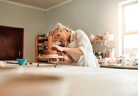 This is where I make handmade functional pottery. a female artisan working in Stock Photos
