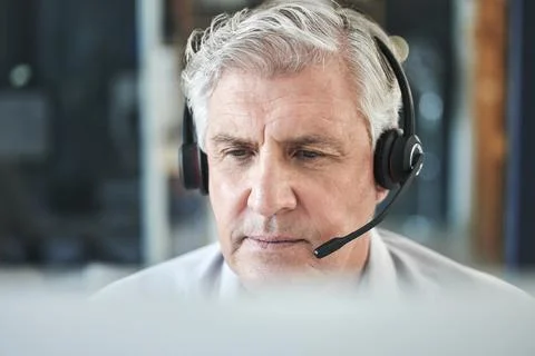 Where is the problem. Shot of a mature call centre agent sitting alone in the Stock Photos