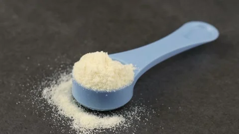 Whey Protein Powder in measuring scoop. Stock Photo