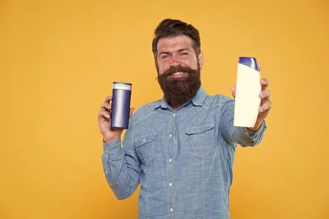 Which one is better. Man hold shampoo bottles. Hair care. Shampoo for daily use Stock Photos