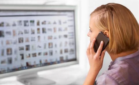 Which one do I click again. Shot of a young woman talking on the phone while Stock Photos