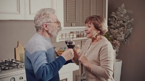 While everyone is sleeping, a happy old couple having fun drinking wine talking Stock Footage 234990078