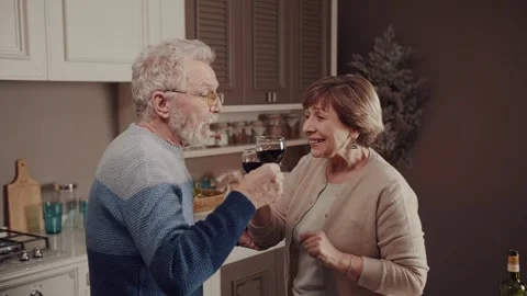 While everyone is sleeping, a happy old couple having fun drinking wine talking Stock Footage 234990447